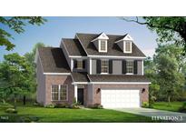 Charming two-story home with a brick and siding exterior, dormer windows, and a two-car garage at 1091 Channel Drop Lp, Zebulon, NC 27597