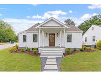 Charming white home with a welcoming front porch and landscaped yard at 1112 Watauga Street St, Raleigh, NC 27604