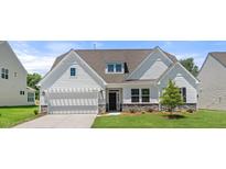 Charming home with a white exterior, well-manicured lawn, a two-car garage and stone accents at 1306 Cricket St, Elon, NC 27244