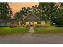 Charming single-story home featuring a welcoming front porch and well-maintained landscaping at 1414 Walter Bright Rd, Sanford, NC 27330