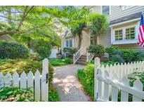 Charming home exterior featuring a welcoming entrance with lush greenery and a white picket fence at 1712 Briarforest Pl, Raleigh, NC 27615