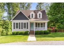 Charming home with manicured front lawn and inviting front porch in a serene, wooded setting at 200 Weybossett Rd, Henderson, NC 27537