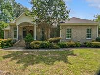 Charming brick home featuring a manicured lawn, elegant columns, and a welcoming front porch at 280 Dreamcatcher Trl, Youngsville, NC 27596