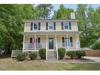 Charming two-story home with a welcoming front porch and neatly landscaped yard at 300 Hutchins Dr, Garner, NC 27529