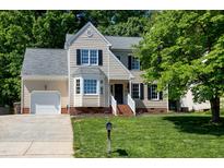 Charming two-story home with a well-manicured lawn, attached garage, and inviting front porch at 300 Silvercliff Trl, Cary, NC 27513