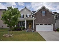 Charming two-story home featuring a brick and siding exterior and a well-maintained front yard at 3032 Curling Creek Dr, Apex, NC 27502