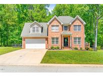 Charming two-story brick home featuring a well-manicured lawn and a two-car garage at 3436 Candlebrook Ct, Mebane, NC 27302