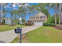 Charming two-story home with a well-manicured lawn and a long driveway leading to an attached two-car garage at 35 Pine Water Way, Spring Lake, NC 28390