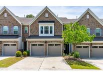 Charming brick townhome featuring an attached garage and manicured landscaping at 525 Durants Neck Ln, Morrisville, NC 27560