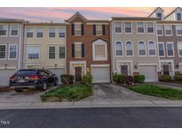 Charming brick townhome with attached garage and manicured front lawn at sunset at 5504 Crabtree Park Ct, Raleigh, NC 27612