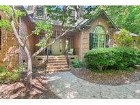 Charming brick home featuring a welcoming front porch, mature landscaping, and a classic design at 5524 Jomali Dr, Durham, NC 27705