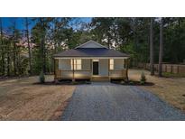 Charming single-story home with a cozy front porch and fresh gravel driveway nestled among mature trees at 604 Natchez Trace, Fuquay Varina, NC 27526