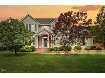 Charming two-story home boasts a manicured lawn and inviting front entrance at sunset at 608 Driftwood Dr, Gibsonville, NC 27249