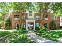 Brick condo building exterior with mature trees and manicured landscaping at 8231 Allyns Landing Way # 302, Raleigh, NC 27615