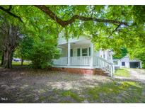 Charming home with a cozy front porch and mature trees providing shade at 1015 Cross Link Rd, Raleigh, NC 27610