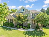 Stunning two-story brick home with a well-manicured lawn and beautiful landscaping at 1046 Covered Bridge Trl, Chapel Hill, NC 27517