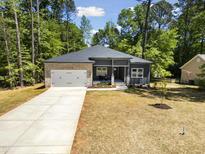 Charming single-story home featuring stone accents, a gray facade, and a well-manicured front yard at 107 Seminole Dr, Louisburg, NC 27549