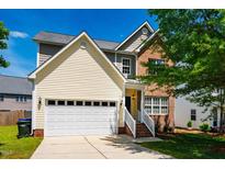 Charming two-story home with a mix of brick and siding, complemented by an attached two-car garage and a well-maintained lawn at 11 Piccadilly Ct, Durham, NC 27713