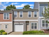 Two-story townhouse with tan siding, white trim, front lawn, and attached one-car garage at 127 Deacon Ridge St, Wake Forest, NC 27587