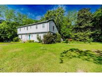 Charming two-story home with light grey siding, surrounded by mature trees and lush green lawn at 1706 Carthage St, Sanford, NC 27330