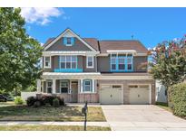Charming two-story home featuring a three-car garage, brick accents, and a well-maintained front yard at 201 Bog Hill Ln, Cary, NC 27519
