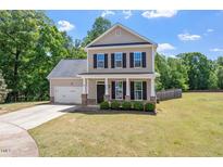Charming two-story home featuring a well-manicured lawn, attached garage, and inviting front porch at 274 Tuscarora Ln, Clayton, NC 27520