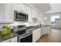 Modern kitchen featuring stainless steel appliances, granite countertops, and white cabinets at 400 W North St # 814, Raleigh, NC 27603