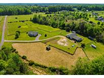 Expansive aerial view of property featuring the home, barn, pastures and lush green acreage at 5916&5918 Laws Farm Rd, Rougemont, NC 27572