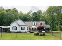 Charming home with white siding, green shutters, and a fenced yard at 67 Bull Run N, Timberlake, NC 27583