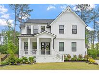 Charming two-story home with a welcoming front porch, black trimmed windows, and beautifully landscaped yard at 7616 Hasentree Way, Wake Forest, NC 27587