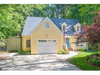 Charming yellow home featuring a well-manicured lawn, attached garage, and mature trees at 829 Joyner Ct, Wake Forest, NC 27587