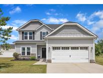 Charming two-story home with a two-car garage, light gray siding, and a well-manicured lawn at 1013 Fieldmere Pl, Wendell, NC 27591