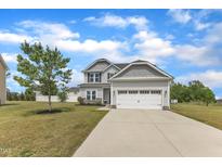 Charming two-story home with a two-car garage and well-maintained lawn at 1013 Fieldmere Pl, Wendell, NC 27591