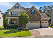 Charming two-story home with a stone and brick facade, a well-manicured lawn, and a two car garage at 106 Mesquite Dr, Durham, NC 27703