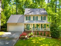 Charming two-story home with a manicured lawn, lush landscaping and a welcoming front porch at 1166 Nc Highway 87 N, Pittsboro, NC 27312