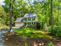 Charming two-story home with a well-manicured lawn, surrounded by mature trees providing shade at 1166 Nc Highway 87 N, Pittsboro, NC 27312