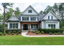Beautiful two-story home with white siding, black shutters, wood porch columns and manicured lawn at 1241 Keith Rd, Wake Forest, NC 27587