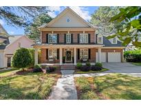Charming brick home with a welcoming front porch, black shutters, and manicured landscaping at 1401 Marshall Farm St, Wake Forest, NC 27587