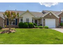 Charming brick home featuring a well-manicured lawn, mature landscaping, and a welcoming front entrance at 1410 Osborne Dr, Burlington, NC 27215