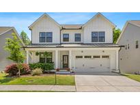 Charming two-story home featuring a classic white facade, black-framed windows, and an attached two-car garage at 1709 Chestnut Falls Rd, Wendell, NC 27591
