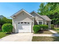 Charming single-Gathering home featuring a well-maintained front yard, garage, and classic architectural details at 20 Keswick Ct, Durham, NC 27713