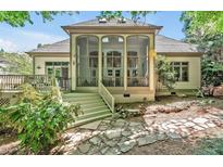 Inviting screened porch features a stone tile path and a charming connection to a backyard deck at 20011 Bragg, Chapel Hill, NC 27517