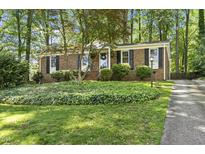 Charming brick home features a manicured front yard and lush landscaping at 215 Westridge Dr, Raleigh, NC 27609