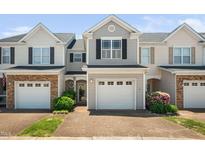 Charming townhome with a single-car garage, manicured landscaping, and neutral siding under a clear blue sky at 2609 Asher View Ct, Raleigh, NC 27606