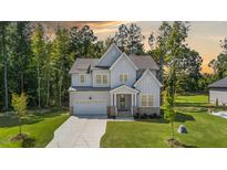 Charming two-story home with stone accents, a manicured lawn, and an attached two-car garage at 300 Scotland Dr, Youngsville, NC 27596