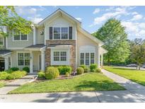 Charming townhome with stone accents, manicured lawn, and lush landscaping provides delightful curb appeal at 302 Red Elm Dr, Durham, NC 27713