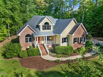 Charming two-story home with brick and siding, a well-manicured lawn, and mature trees at 3035 Tavistock Dr, Durham, NC 27712