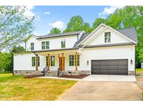 Beautiful two-story home featuring white siding, dark gray roof, and stone accents creating a welcoming curb appeal at 3281 Phillips Chapel Rd, Haw River, NC 27258
