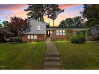 Charming home featuring a brick and vinyl exterior with a walkway and lush green lawn at 3501 Arrowwood Dr, Raleigh, NC 27604