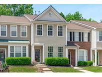 Charming townhouse with light siding, complemented by lush green bushes and a well-manicured lawn at 4535 Sugarbend Way, Raleigh, NC 27606